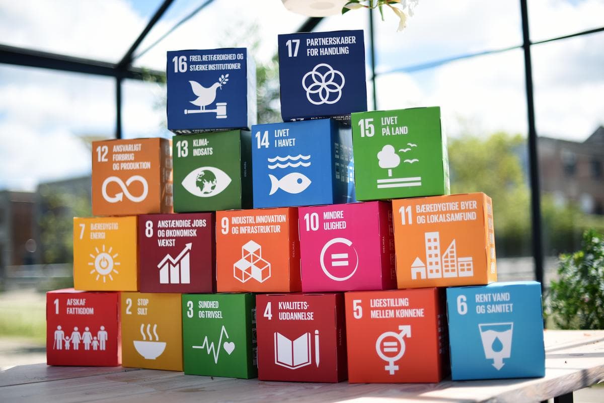 De sytten verdensmål på hver sin kasse, stablet i en pyramide